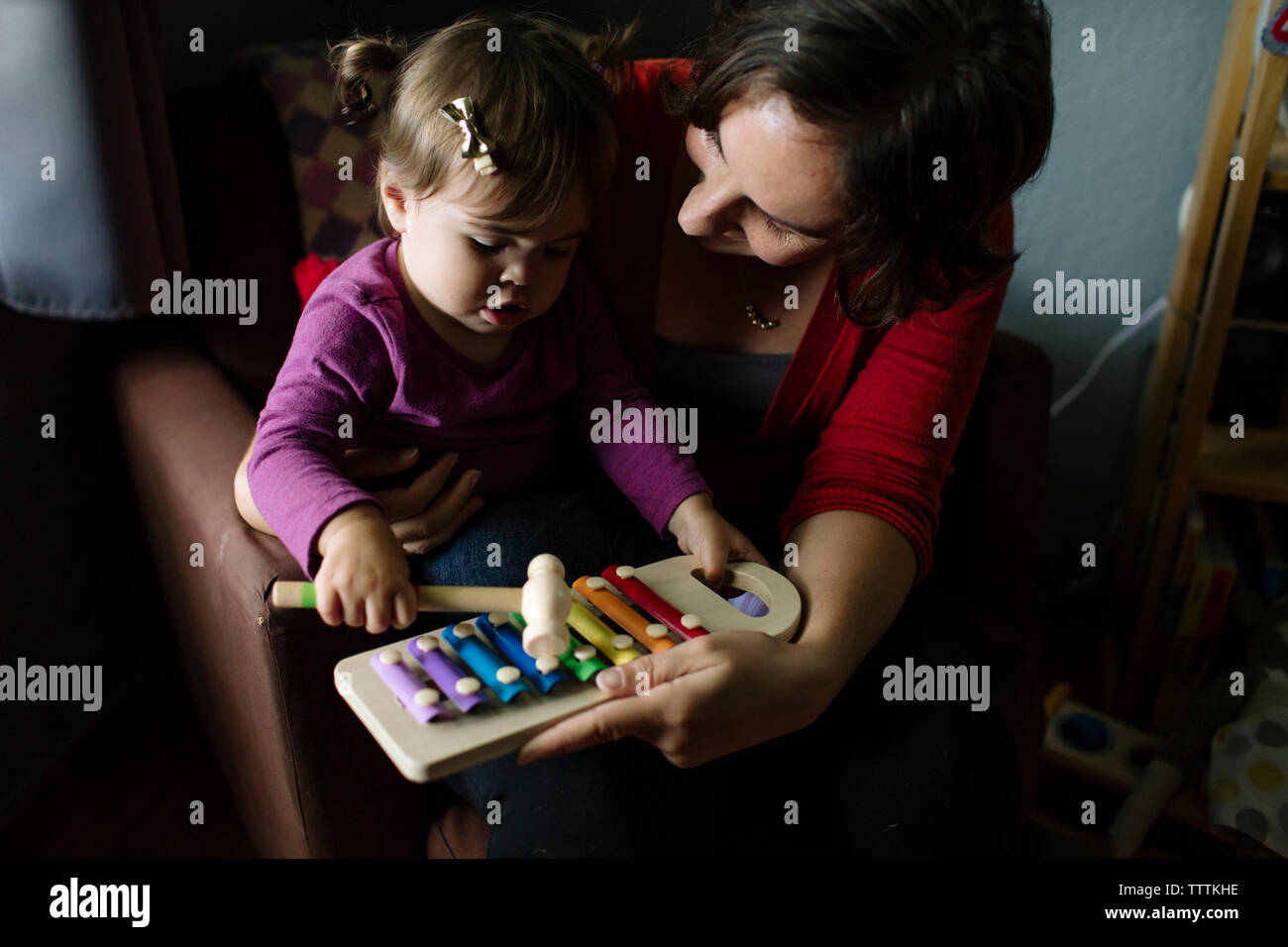 High angle view of mother and daughter playing xylophone at home Stock