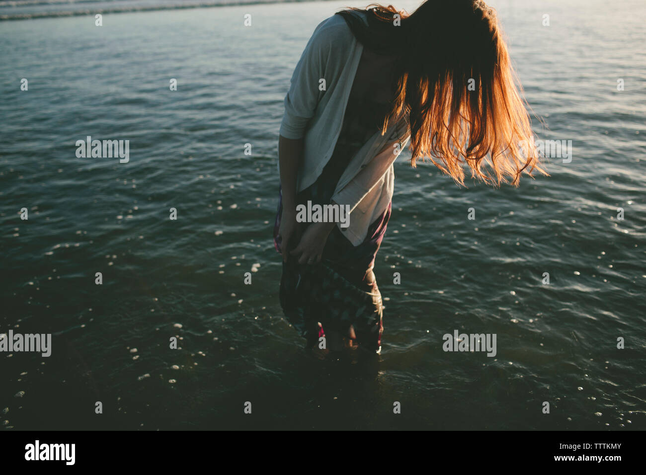 Woman with brown hair standing in sea Stock Photo
