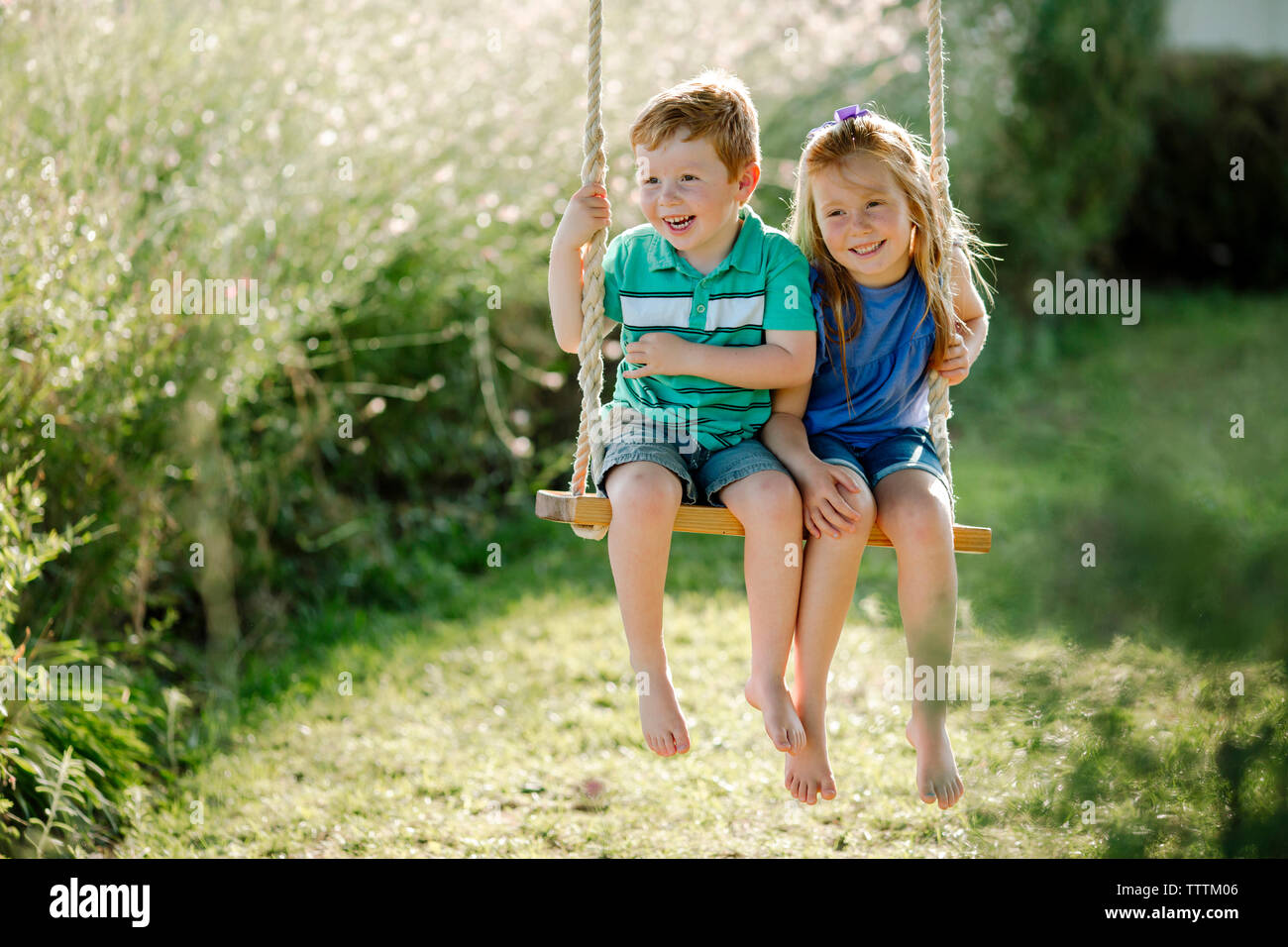 Boy girl sitting on swing hi-res stock photography and images - Alamy