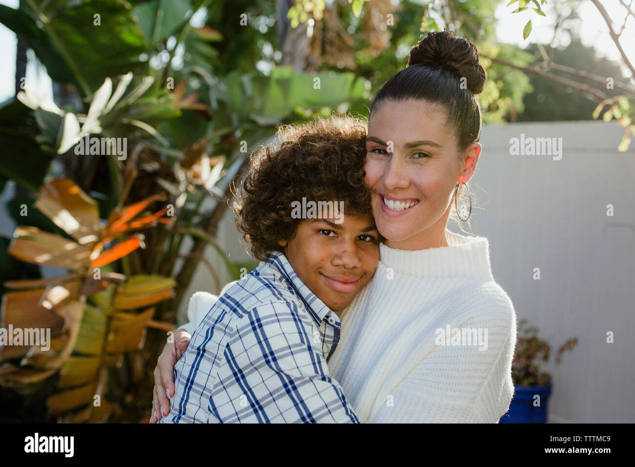 Portrait of loving mother and son embracing at backyard Stock Photo