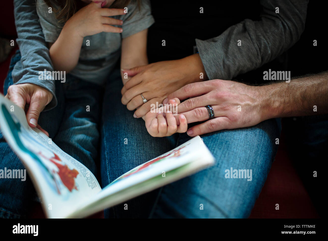 Midsection of family with picture book at home Stock Photo