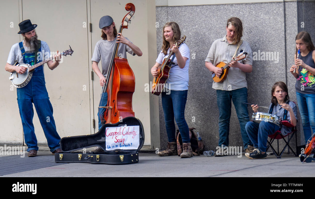 Double bass, banjo, mandolin and acoustic guitar players in  Campbells Calamity Soup musical group busking on the street in  Nashville Tennessee USA.. Stock Photo