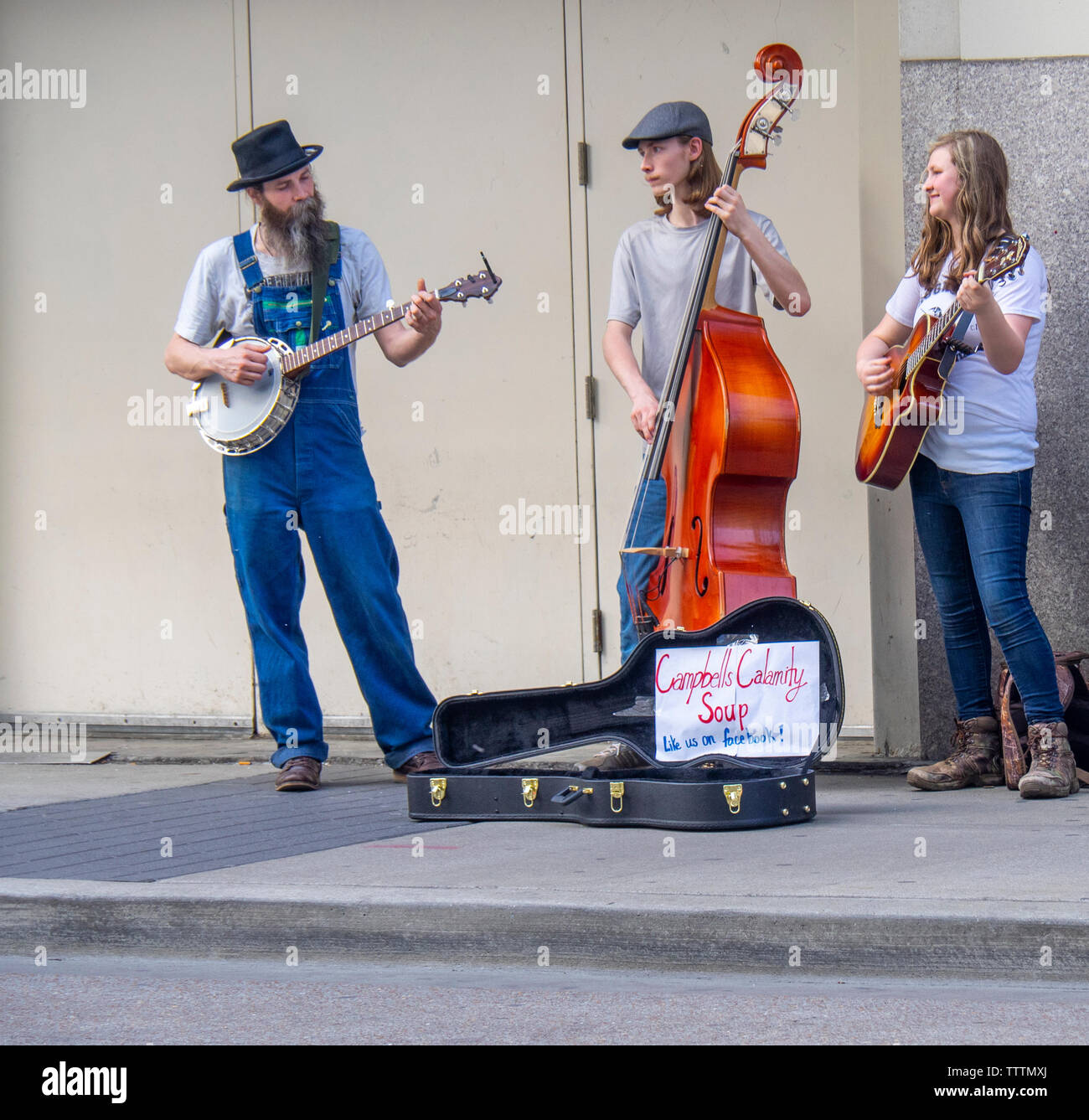 Double bass, banjo and acoustic guitar players in  Campbells Calamity Soup musical group busking on the street in  Nashville Tennessee USA. Stock Photo