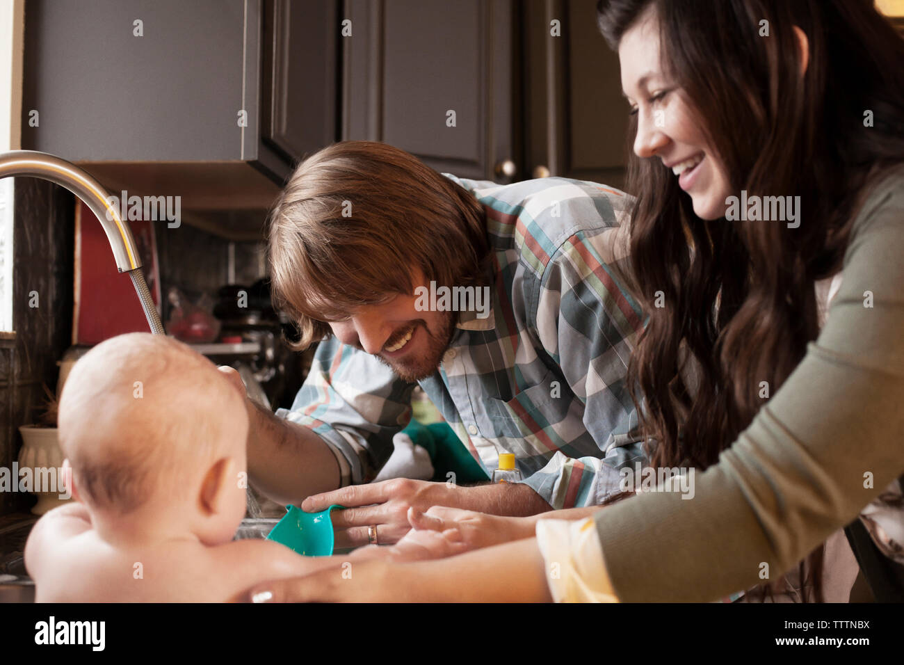 Happy parents bathing baby at home Stock Photo Alamy