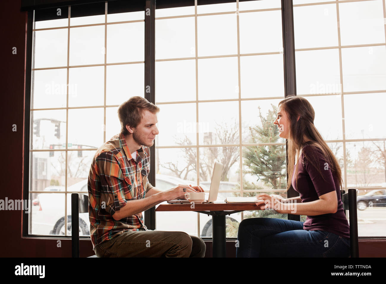 Happy friends sitting at coffee shop by window Stock Photo
