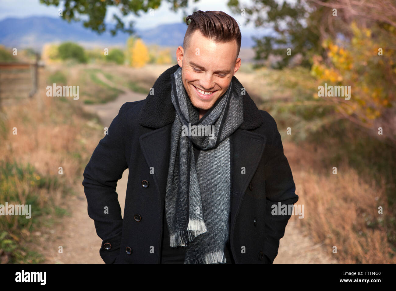 Happy man looking down while walking on pathway Stock Photo Alamy