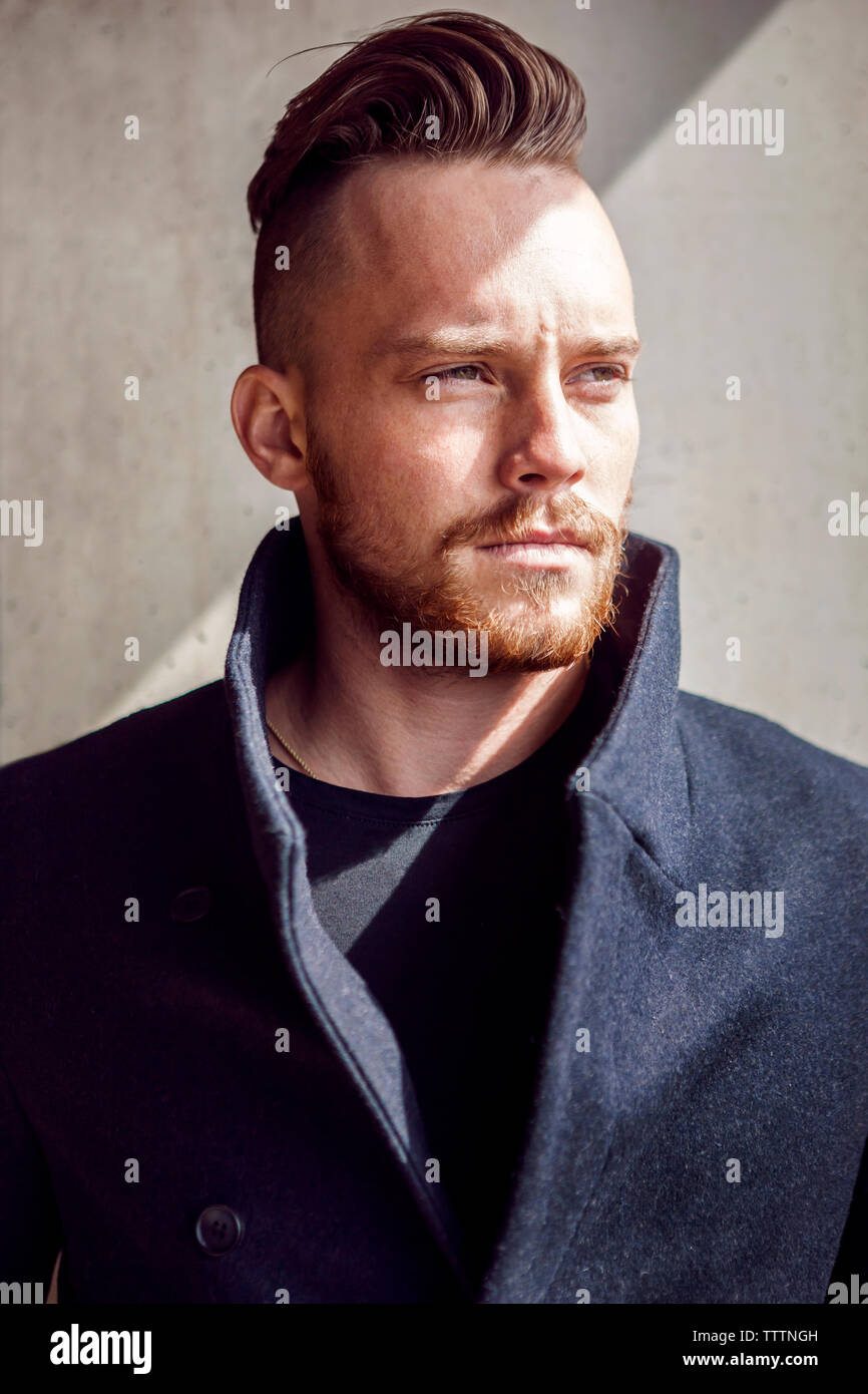 Young man standing front wall hi-res stock photography and images - Alamy