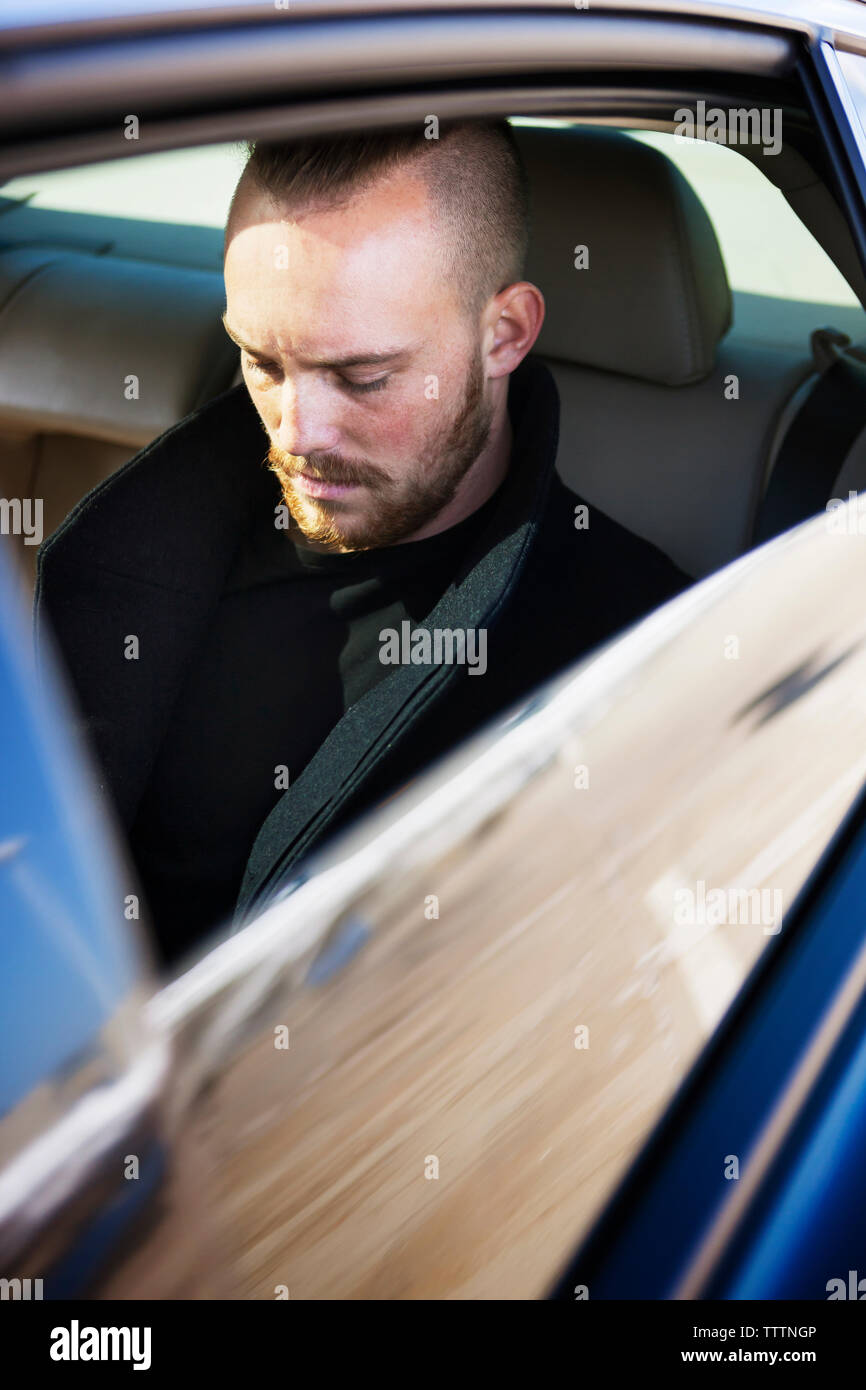 Young man looking down while travelling in car Stock Photo