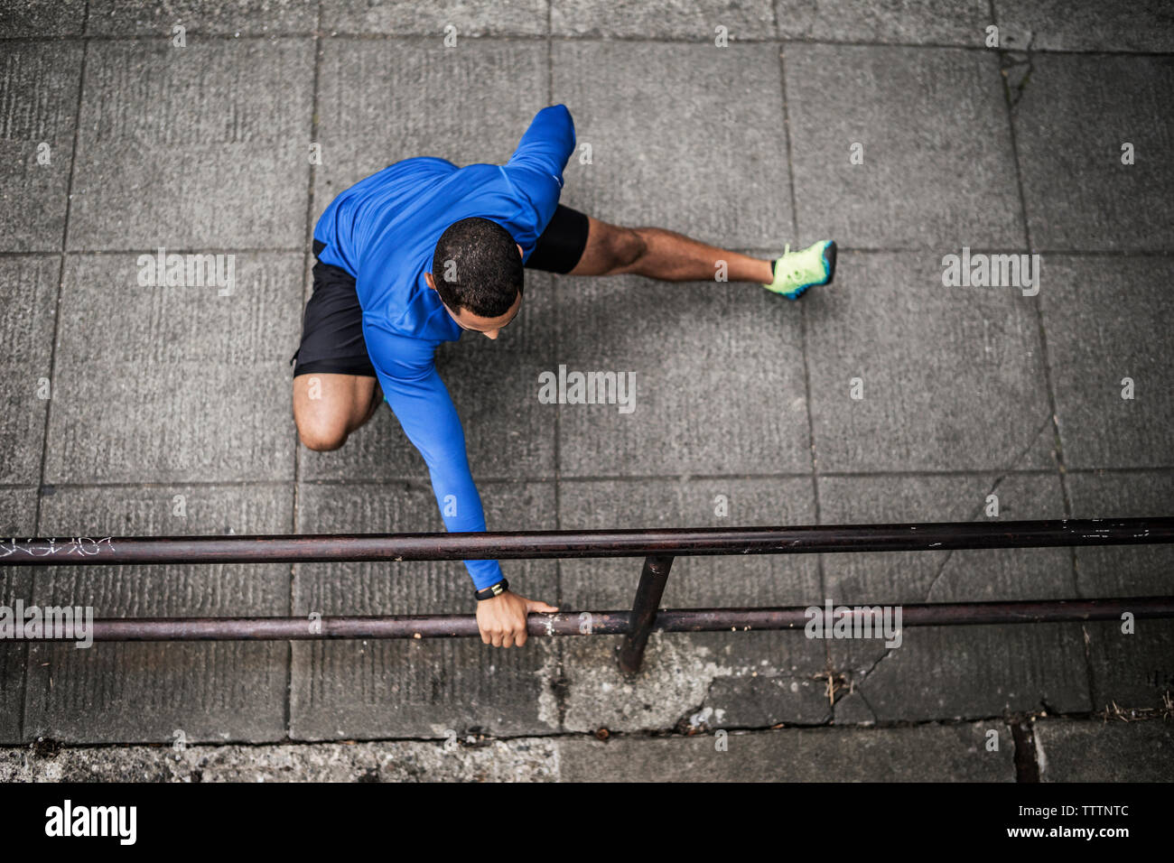 High angle view of exercising by railing on street Stock Photo