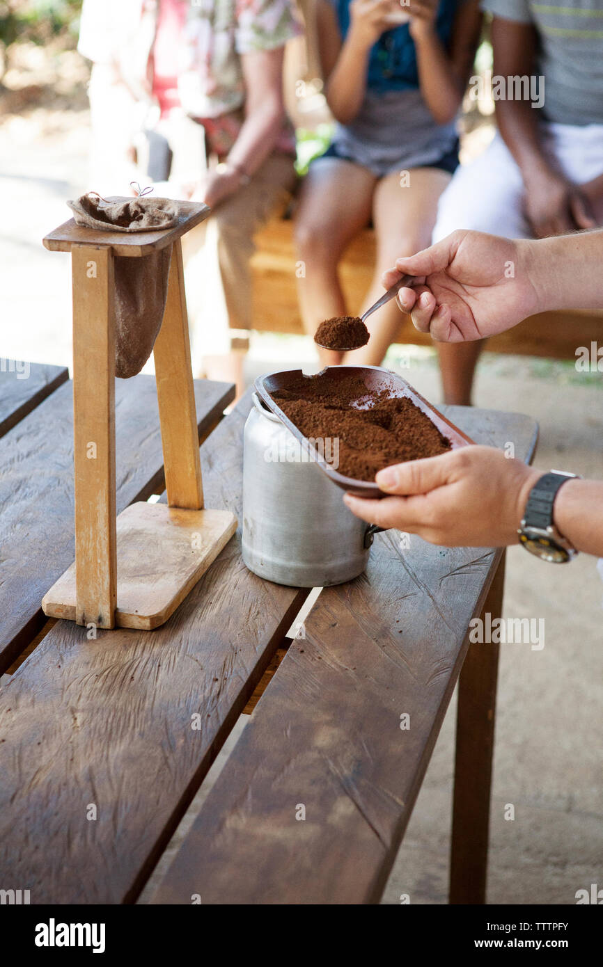 Cropped image of hands with coffee powder while standing by table Stock Photo