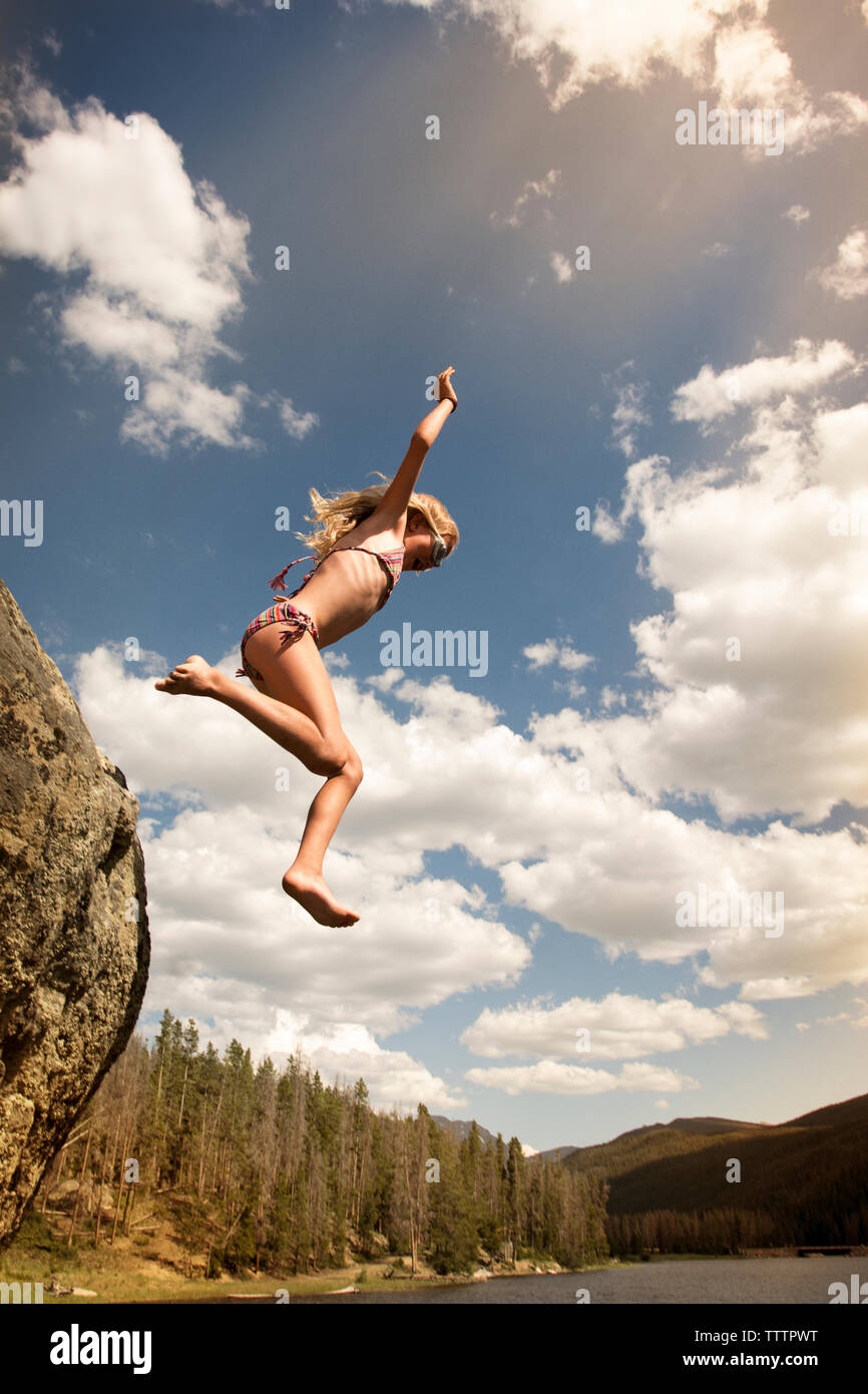 Low angle view of girl diving in lake against sky Stock Photo