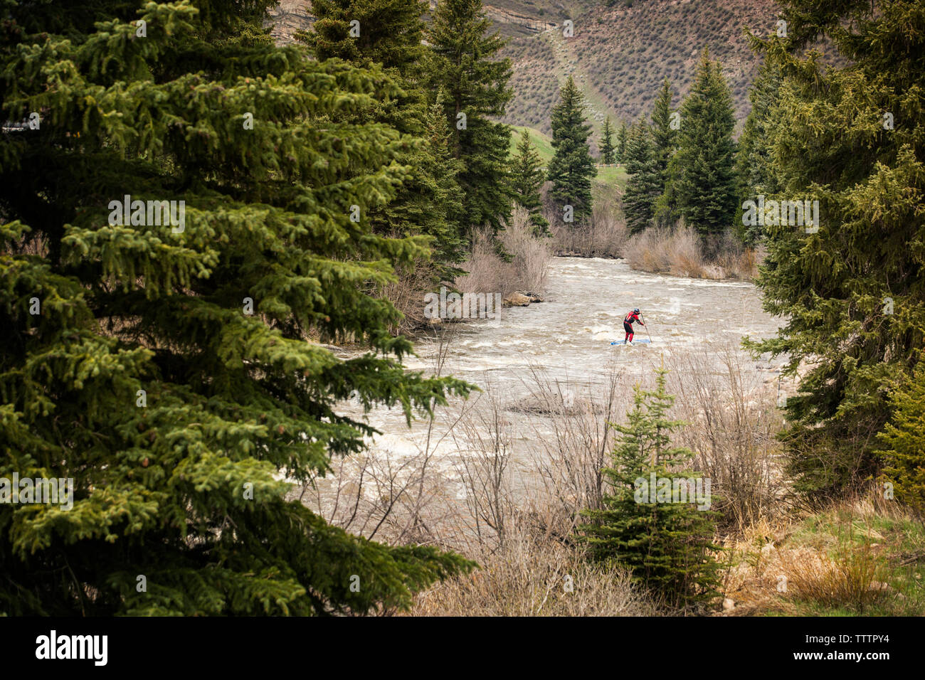 Distant view of paddler paddling in river Stock Photo