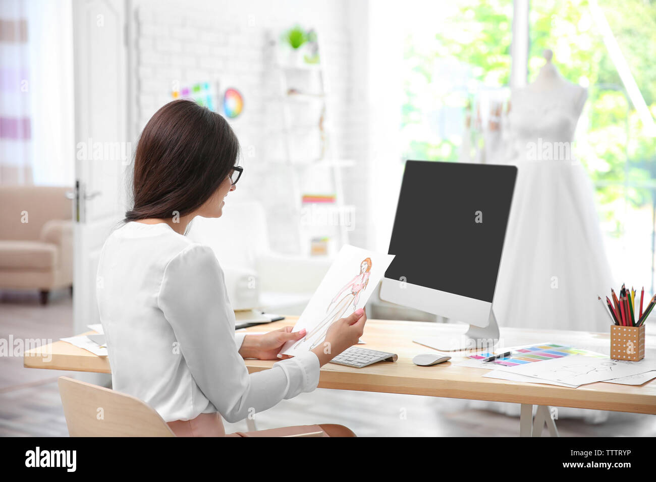 Pretty young dress designer at workplace Stock Photo - Alamy