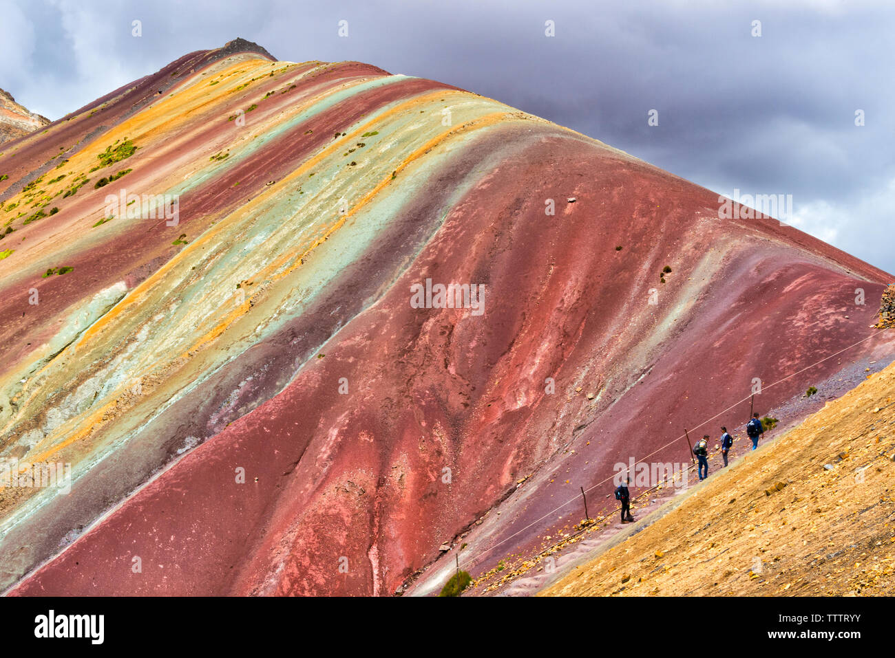 Tourists hiking on the painted hills of the Rainbow Mountain (Vinicunca), Cusco Province, Peru Stock Photo