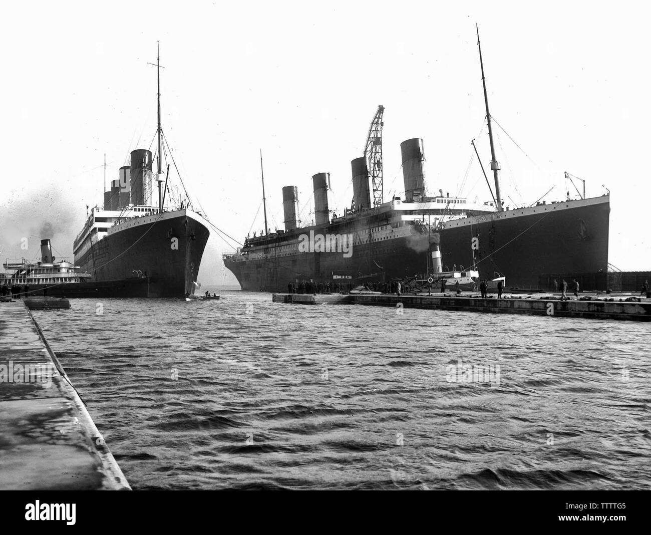 March 6, 1912: Titanic (right) had to be moved out of the drydock so her sister Olympic (left), which had lost a propeller, could have it replaced. Stock Photo