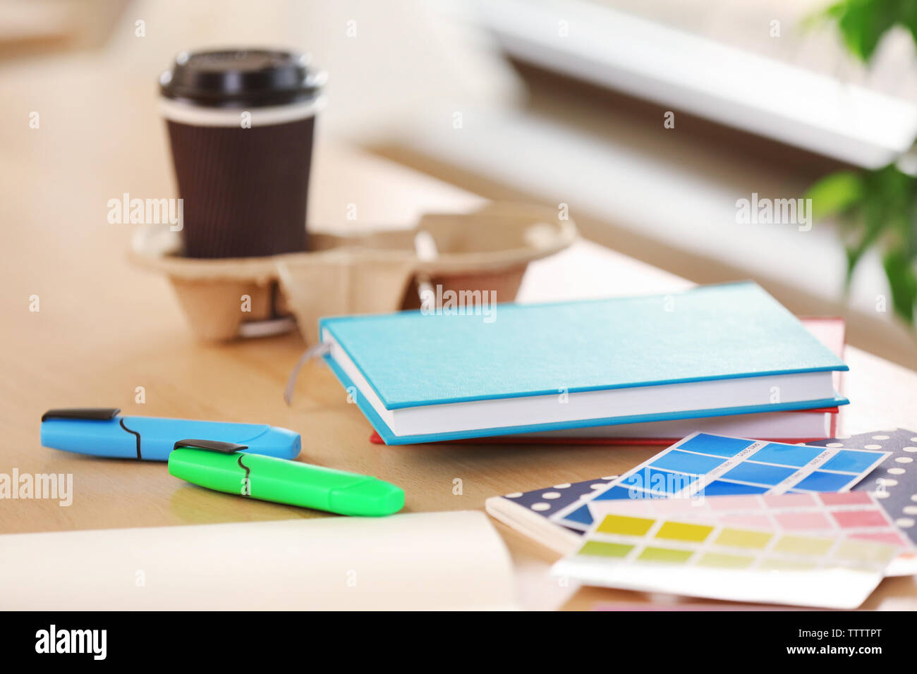 Cup of coffee, colour palette and notebooks on table Stock Photo