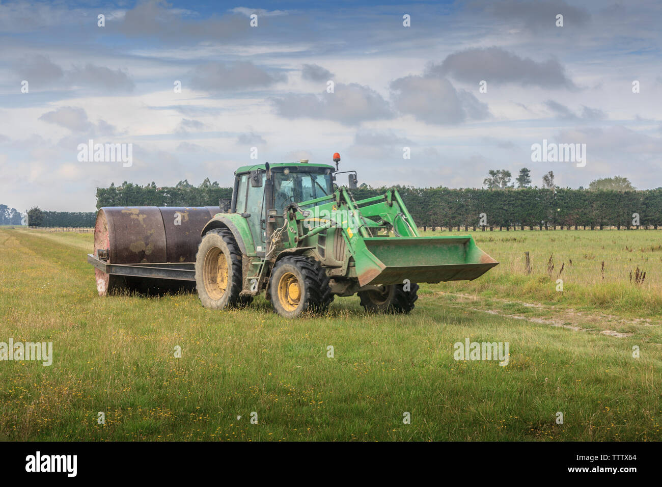 Farmer rolling  a grass paddock Stock Photo