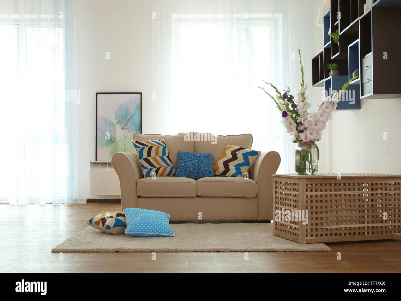 Living room interior with sofa and flowers Stock Photo - Alamy