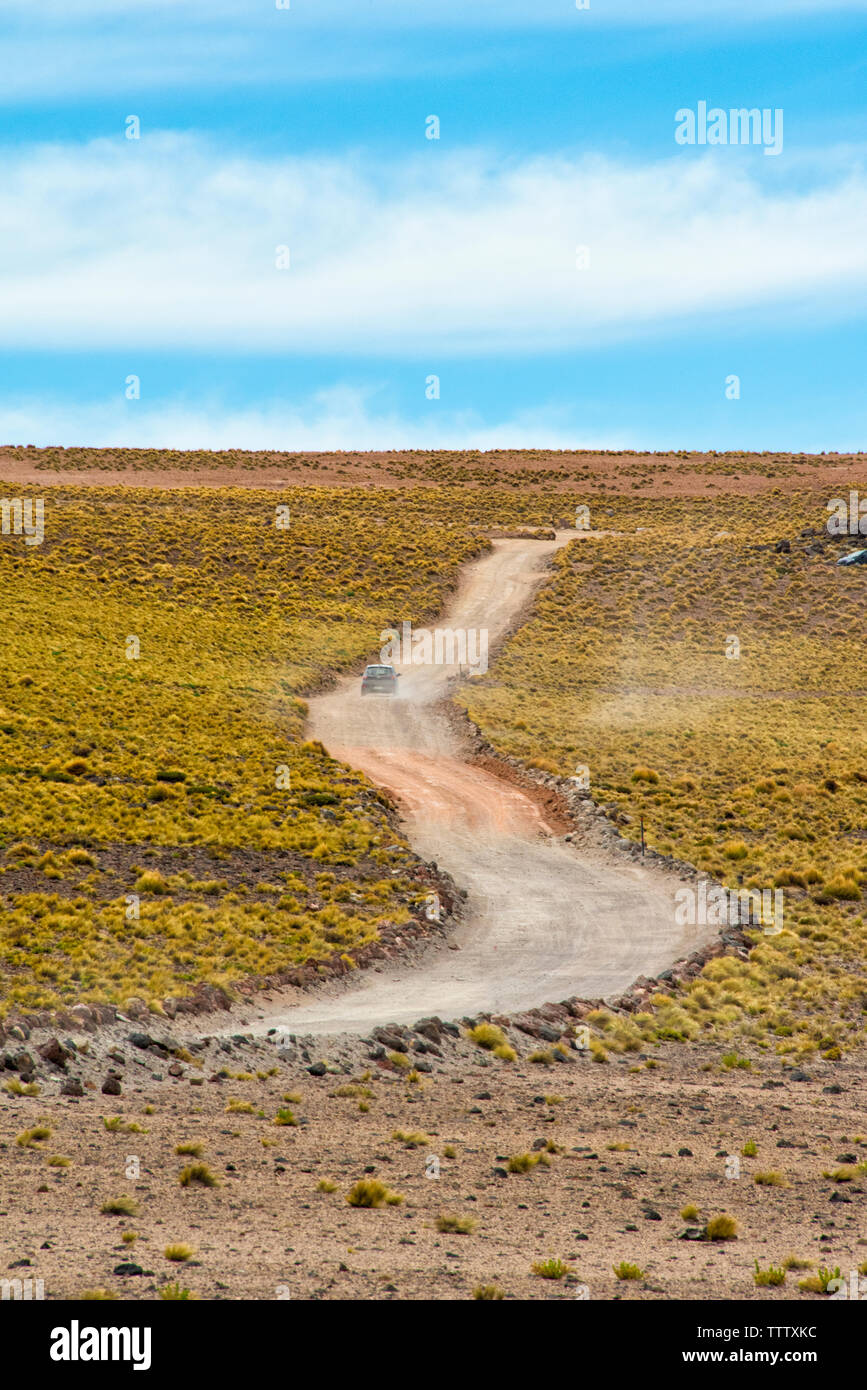 Car driving on road through Atacama Desert, San Pedro de Atacama, Antofagasta Region, Chile Stock Photo