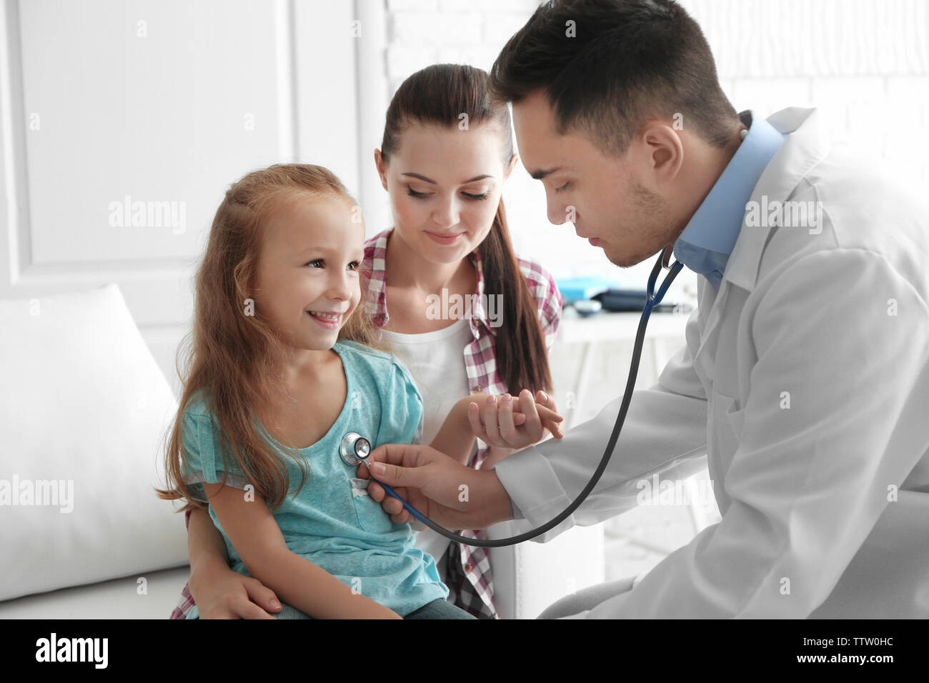 Male pediatrician doctor examining small girl Stock Photo - Alamy