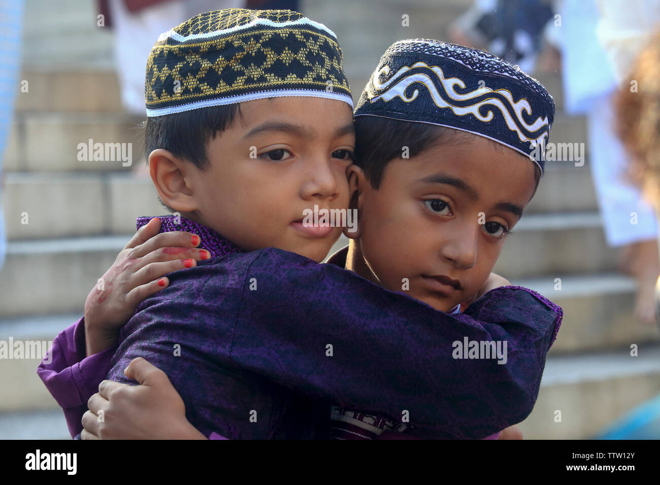 Two children embrace after Eid-ul-Azha congregation at the Baitul Mukarram National Mosque in Dhaka, Bangladesh. Stock Photo