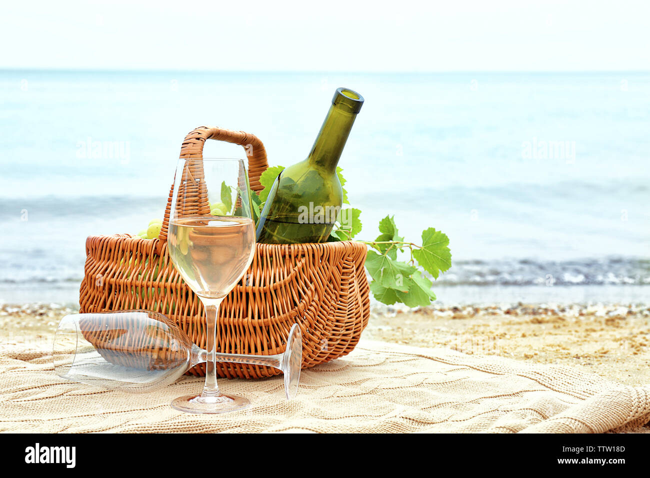 Glasses, basket with bottle and fresh grapes on beach Stock Photo - Alamy