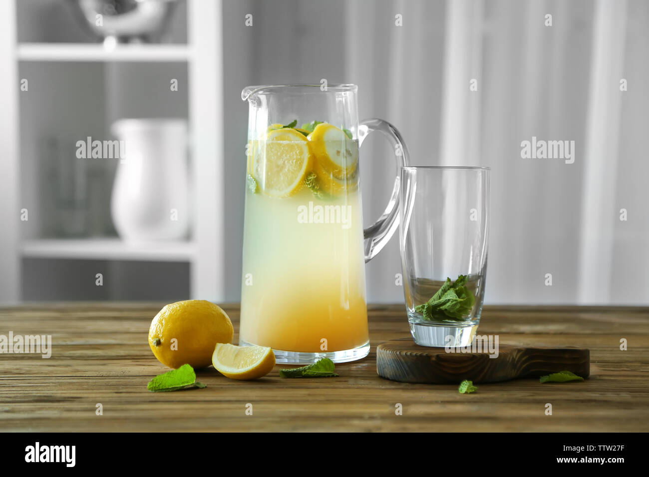 Glass jug with lemonade on wooden table Stock Photo