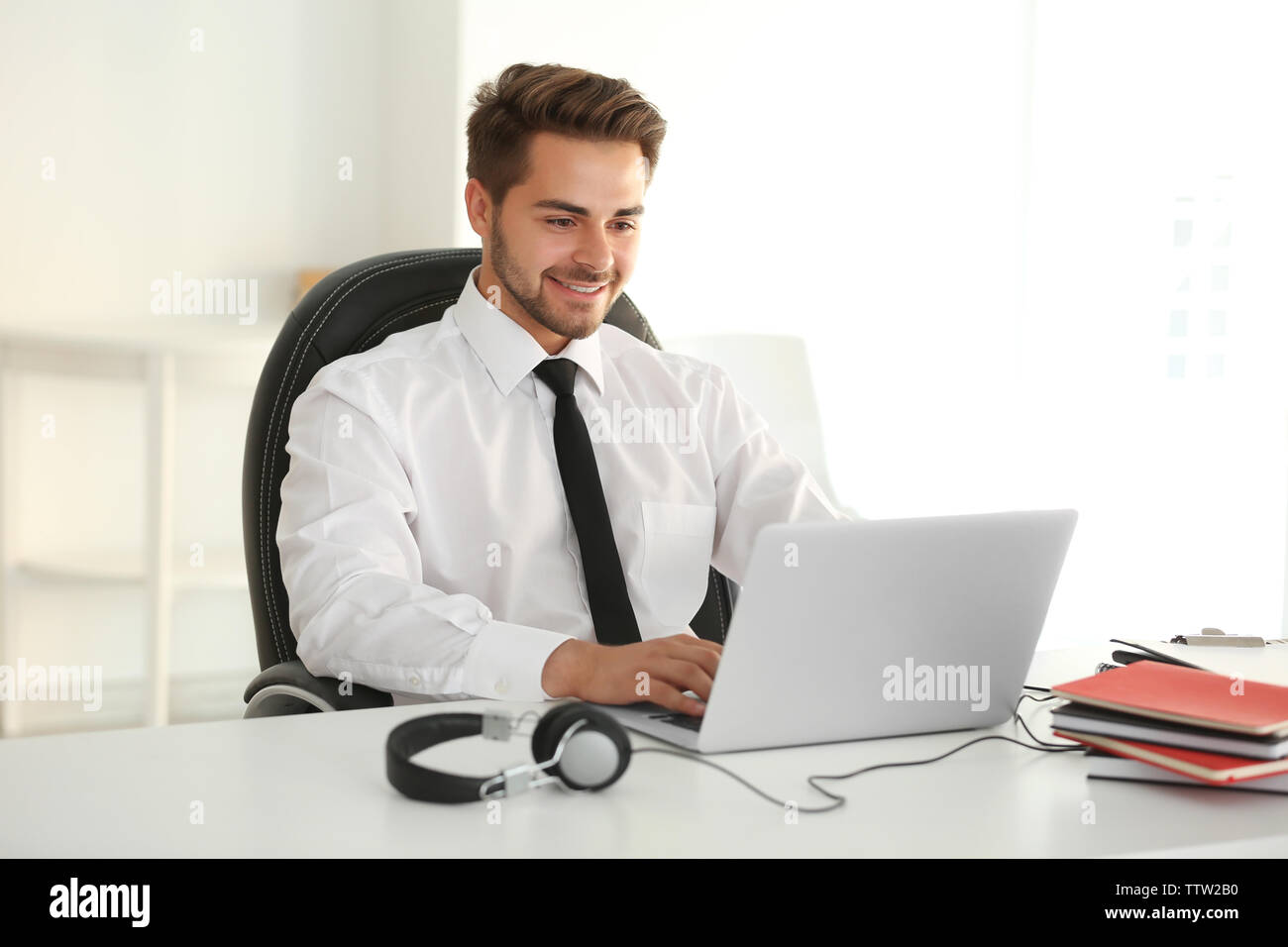 Handsome young man working on laptop in office Stock Photo
