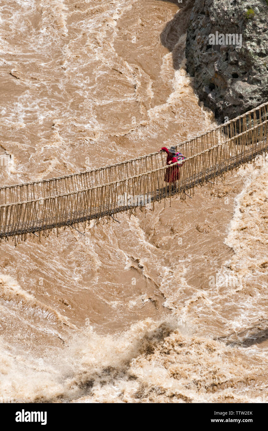 Quechua woman crossing Queshuachaca (Q'eswachaka) rope bridge, one of