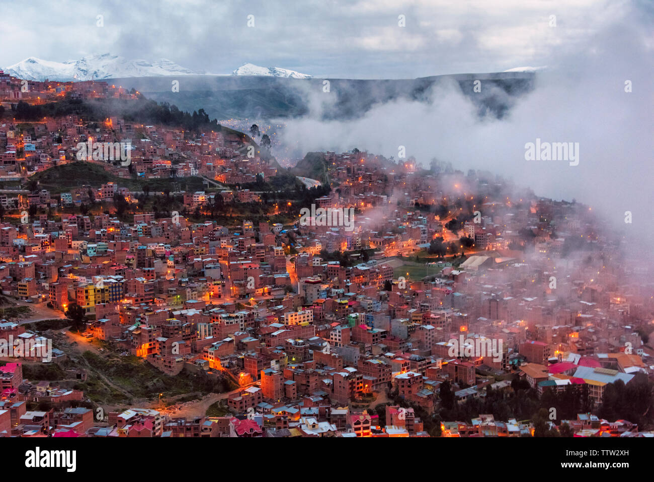 Aerial view of La Paz cityscape with Andes Mountain shrouded in clouds at dawn, Bolivia Stock Photo