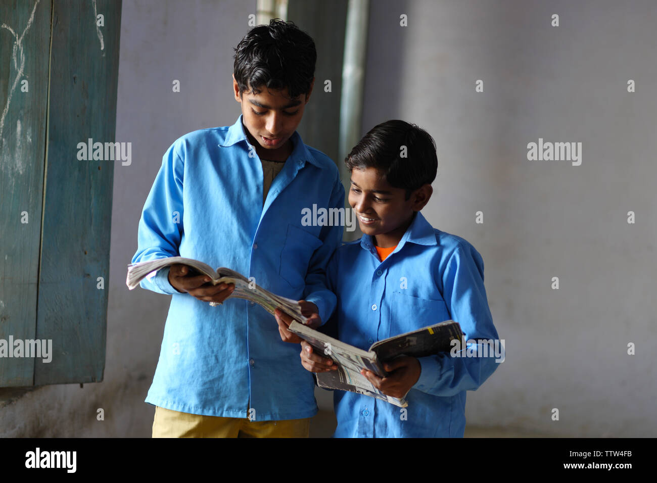 Two schoolboys reading books in a classroom Stock Photo