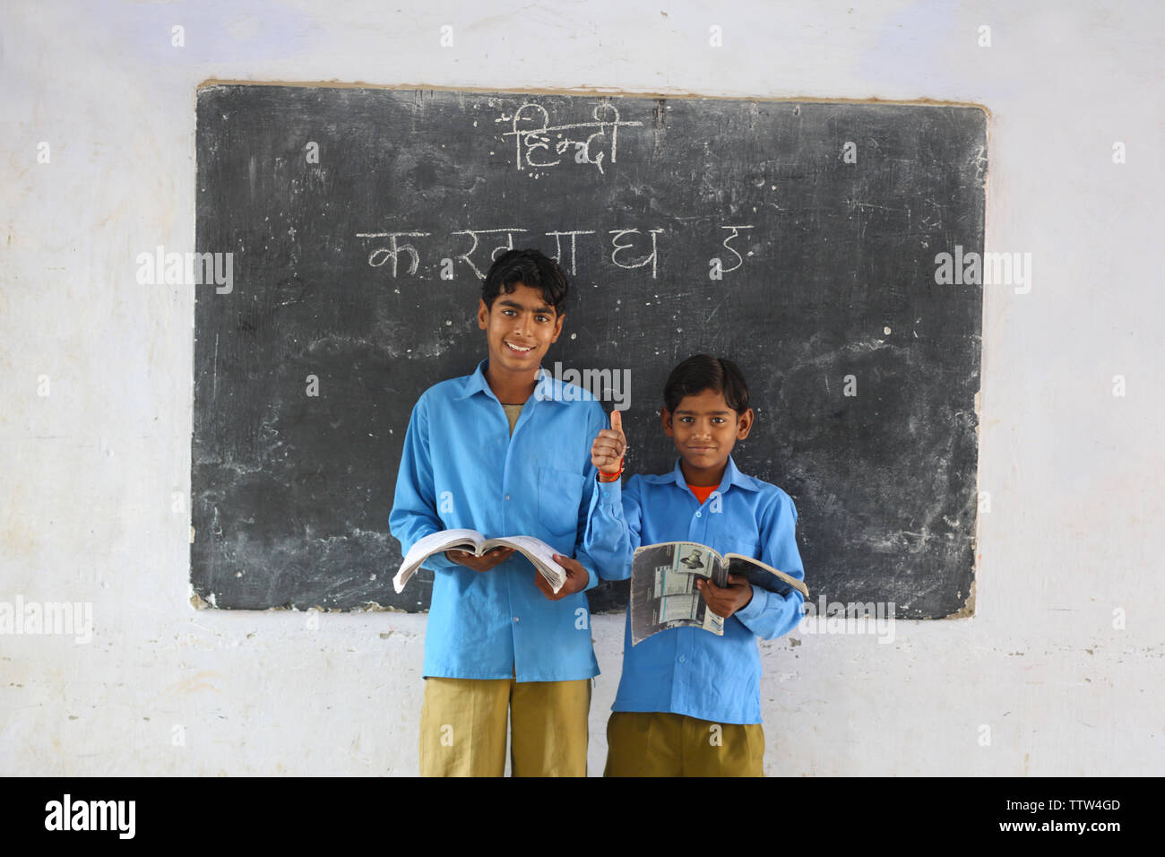 Two schoolboys reading books in a classroom Stock Photo