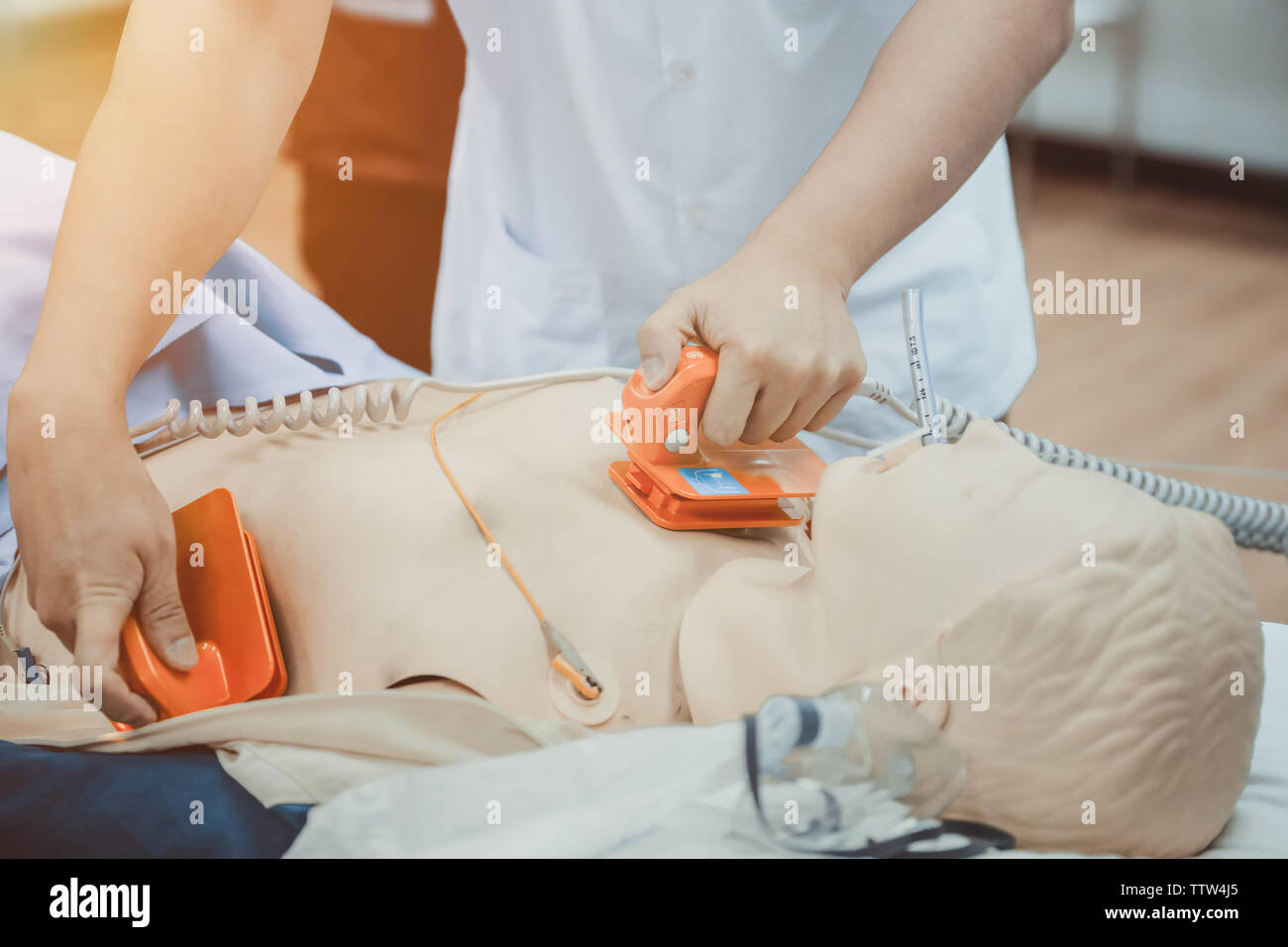 hands of doctor holding defibrillator electrods, performing defibrillation or electropulse therap Stock Photo