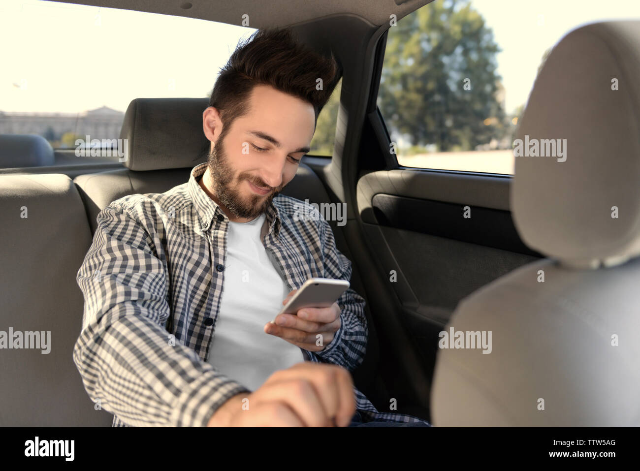 Successful young man using mobile phone while sitting in car Stock Photo