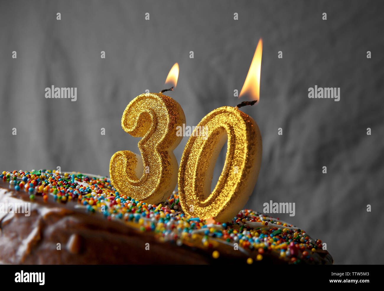 Birthday cake with burning candles on grey background Stock Photo - Alamy