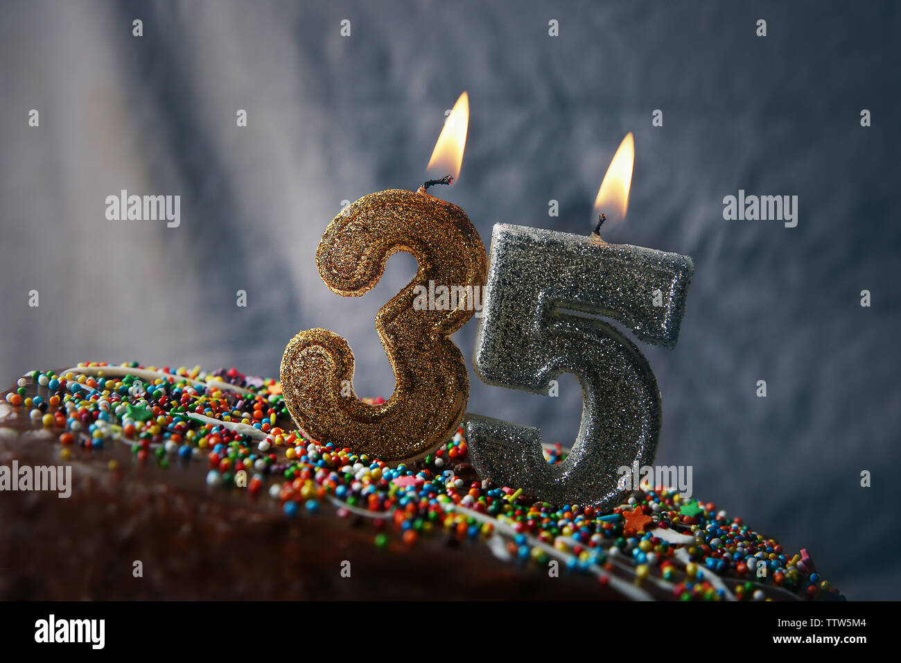 Birthday cake with burning candles on grey background Stock Photo - Alamy