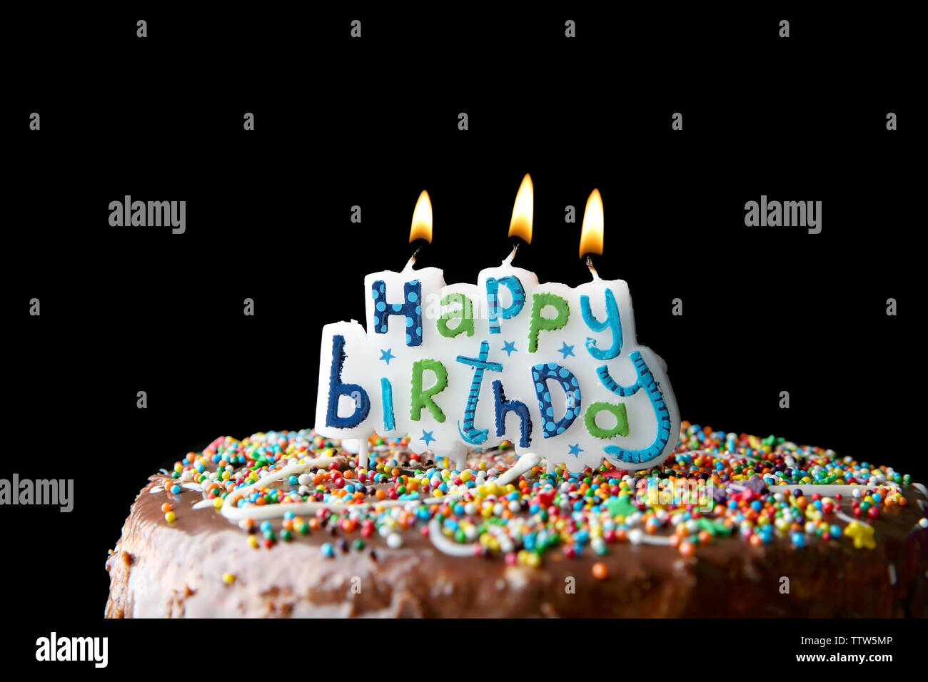 Birthday cake with greeting candles on dark background Stock Photo - Alamy