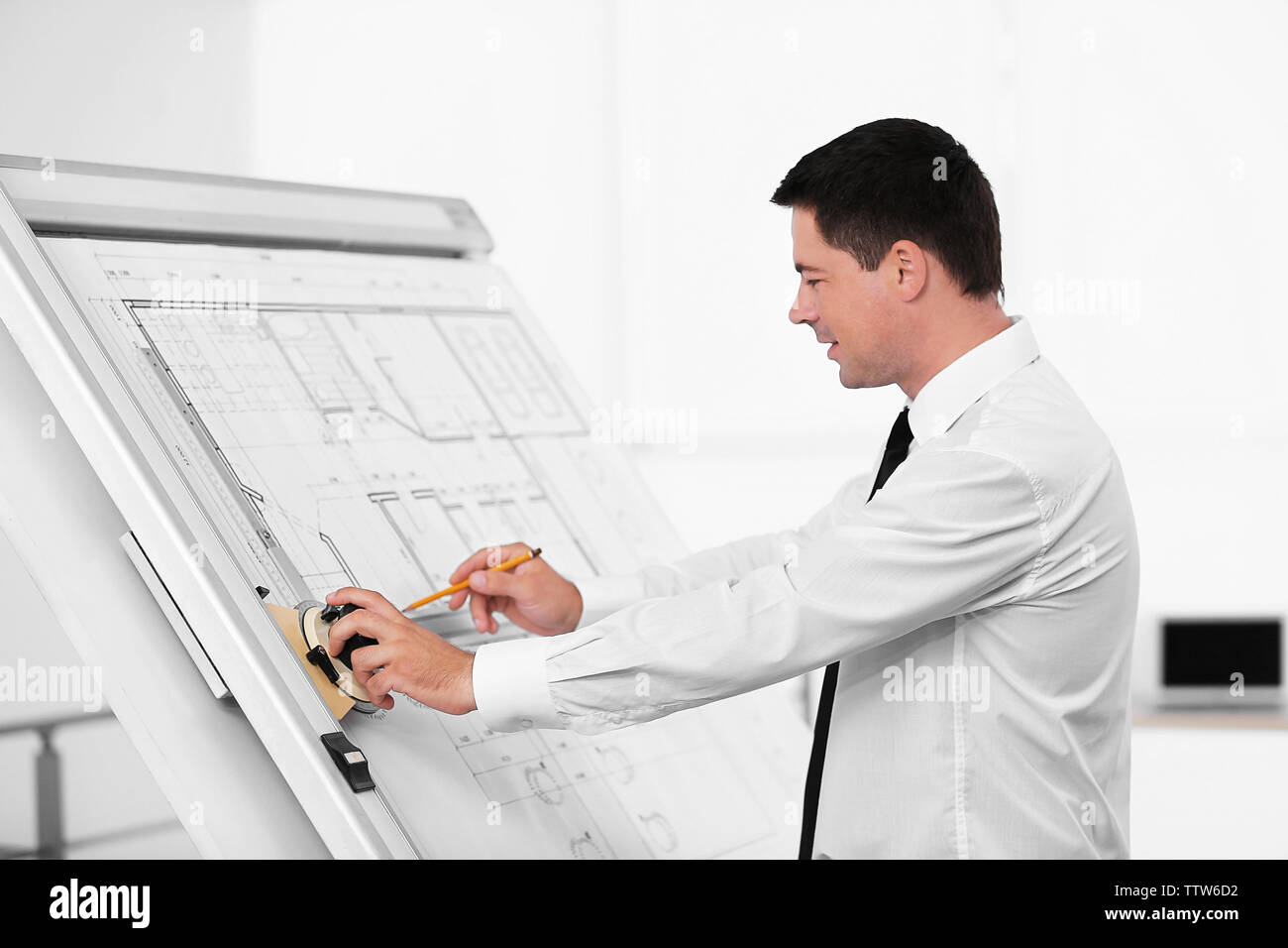 Young creative male engineer making project on drawing board Stock Photo