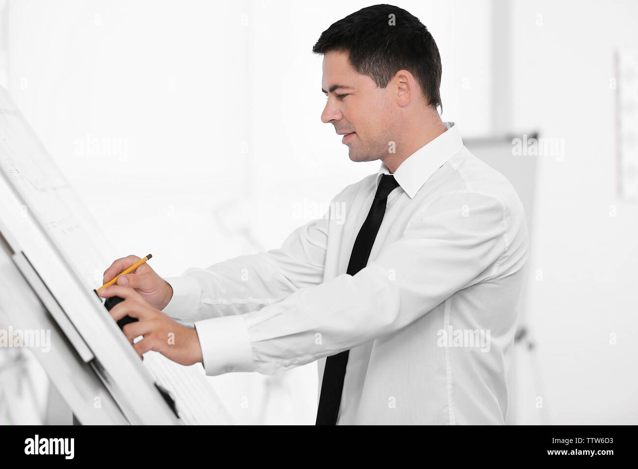 Young creative male engineer making project on drawing board Stock Photo