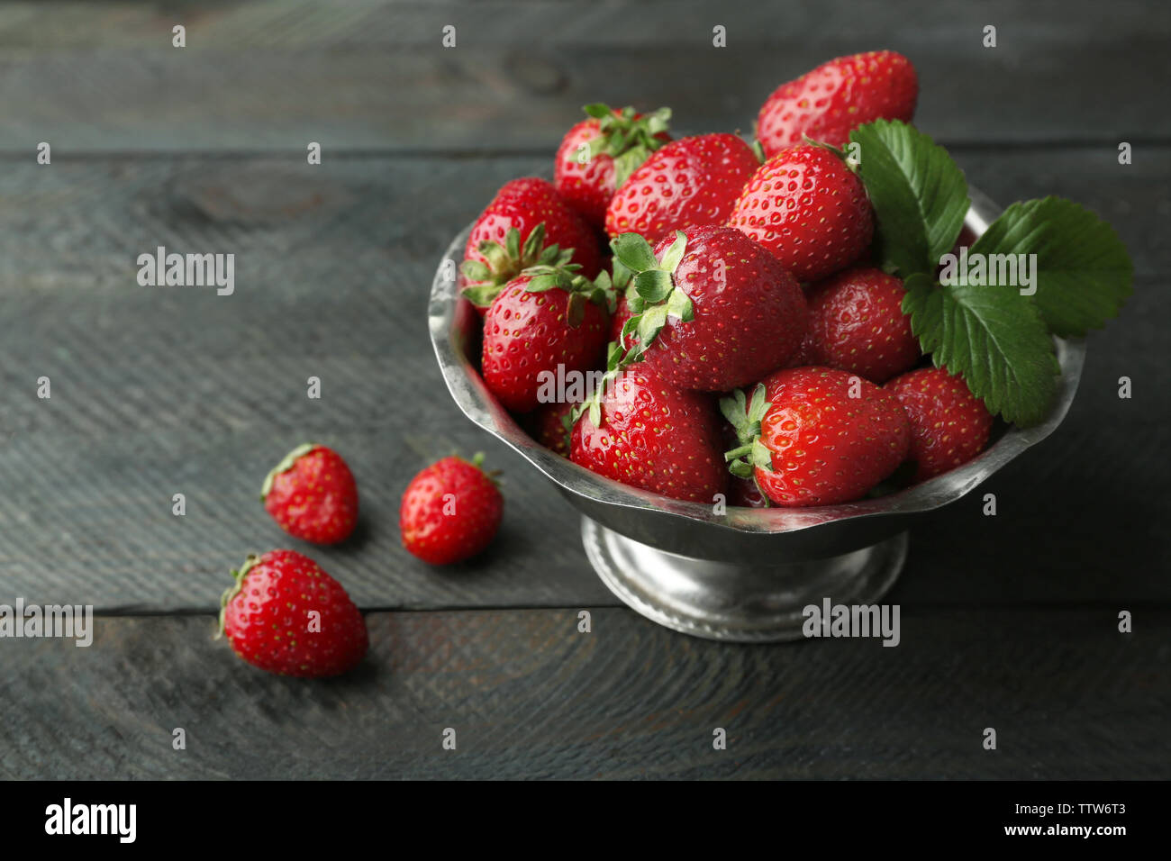 Metal bowl with ripe strawberries on dark wooden background Stock Photo ...