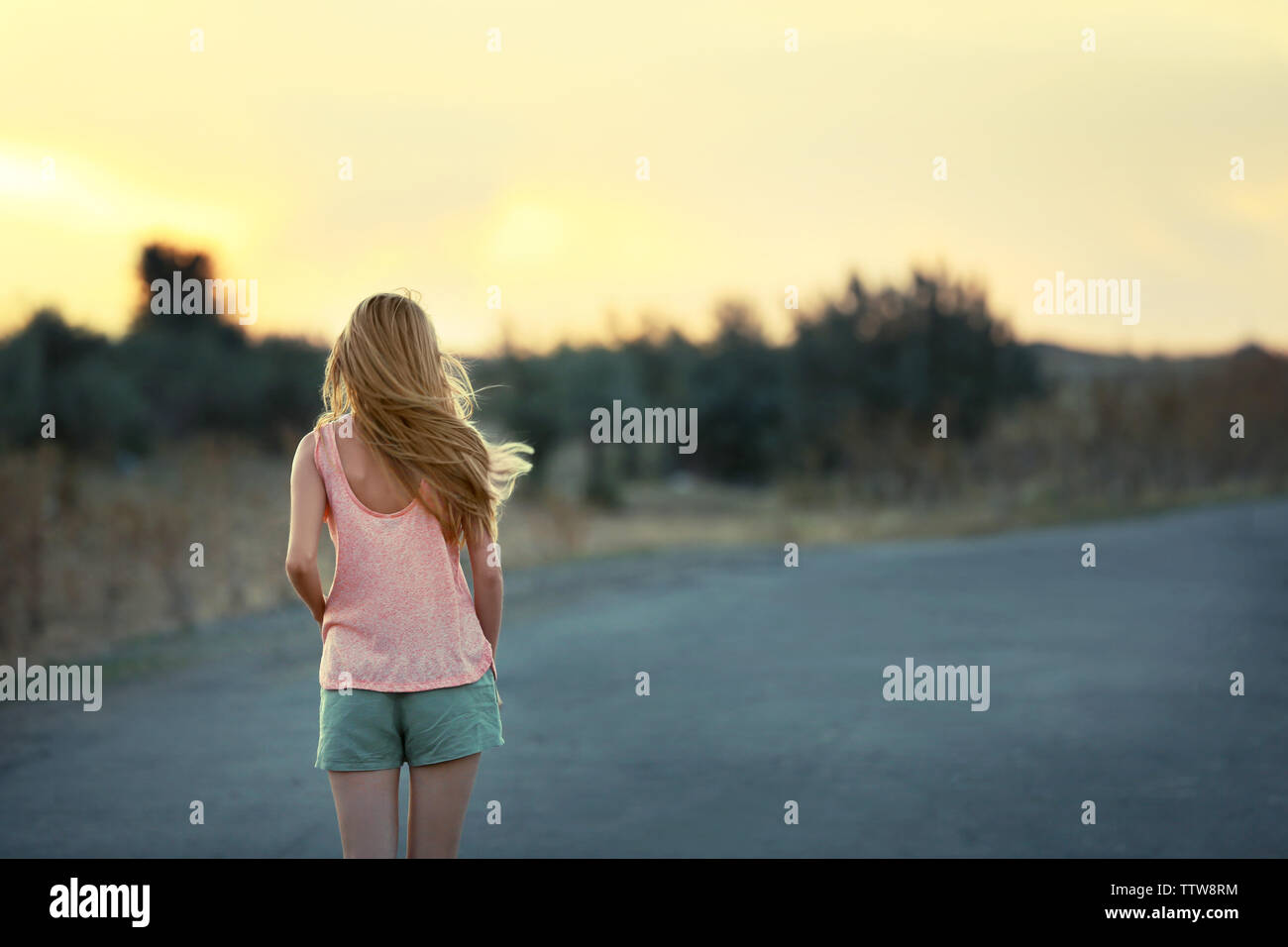 Young woman on sunset sky background Stock Photo - Alamy