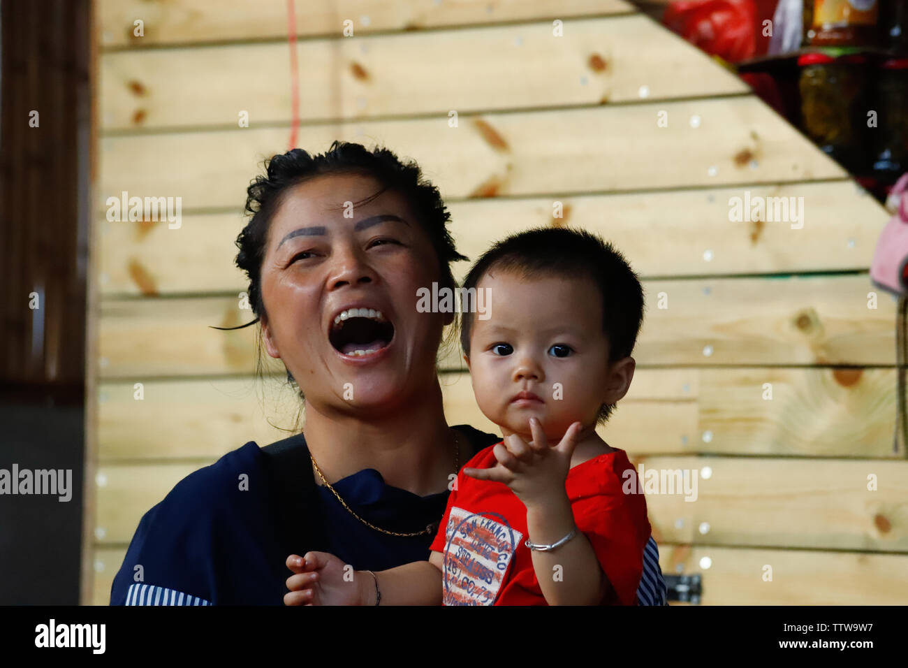 A smiling mom with the baby in a village in southern Yunnan, China. Yunnan, China - November, 2018 Stock Photo
