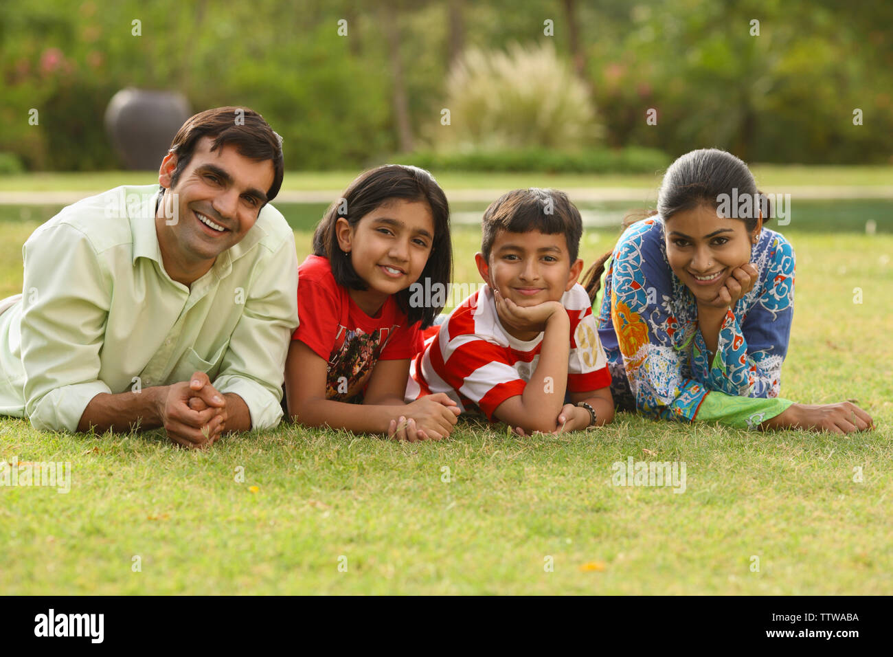 Family lying on grass Stock Photo - Alamy