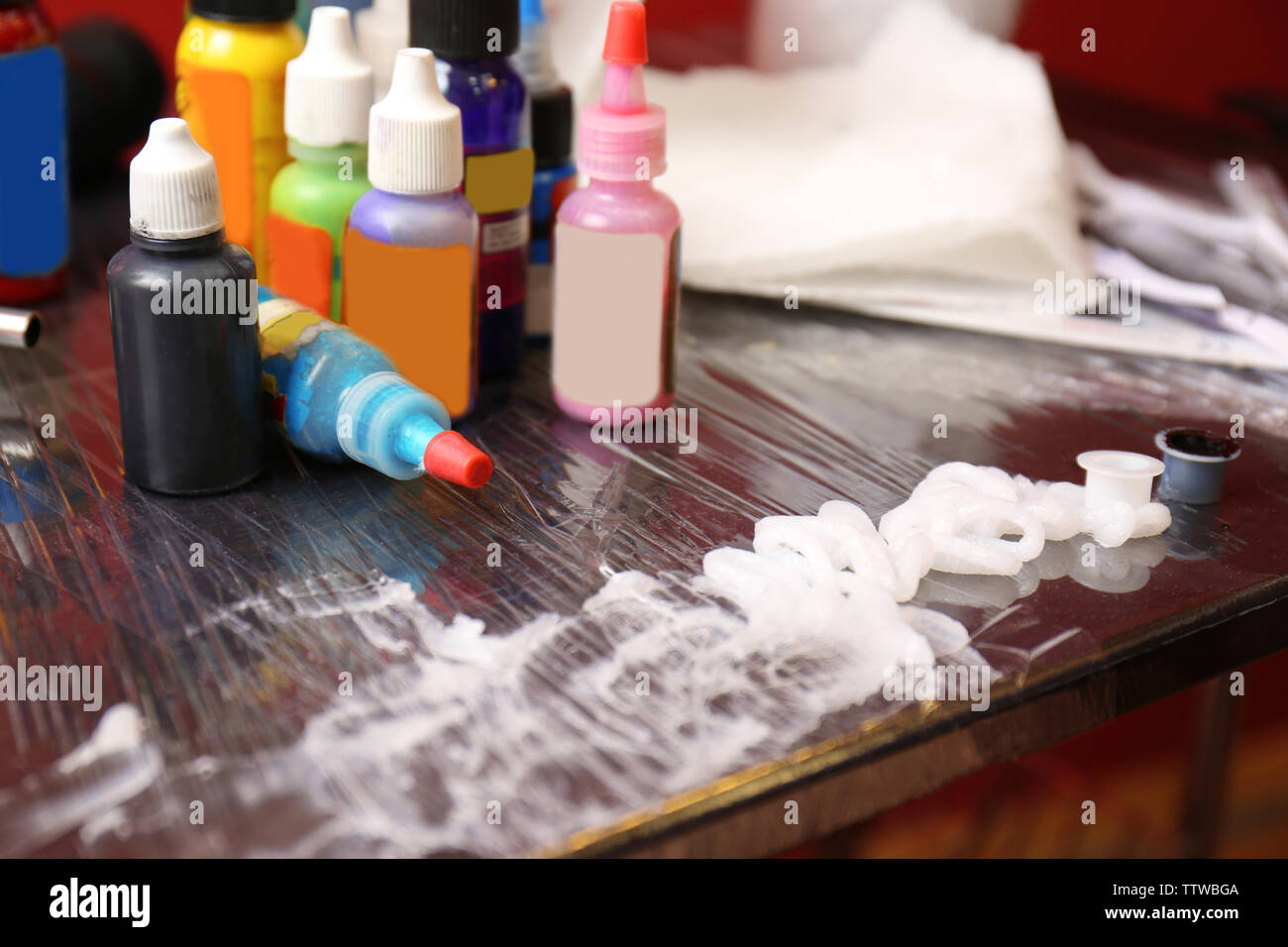 Bottles with tattoo colorful inks and petroleum jelly on wooden table,  close up view Stock Photo - Alamy