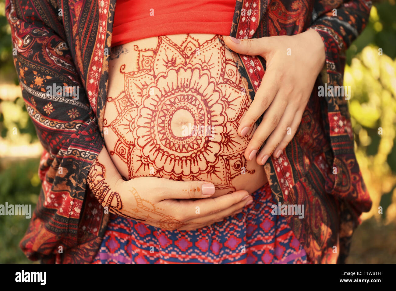 Young pregnant woman with henna tattoo on belly in park Stock Photo Alamy