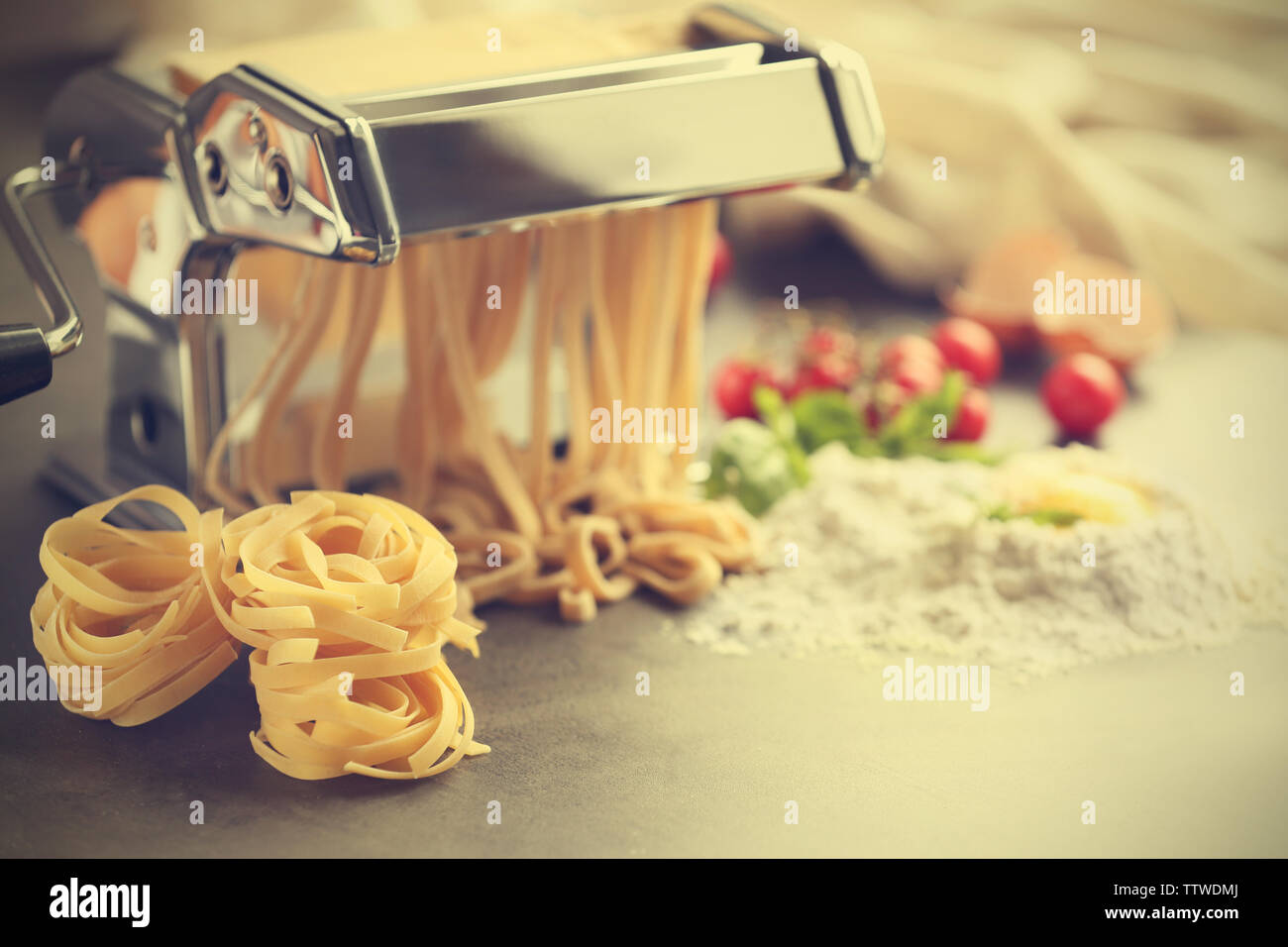 Making tagliatelle with pasta machine on kitchen table Stock Photo Alamy