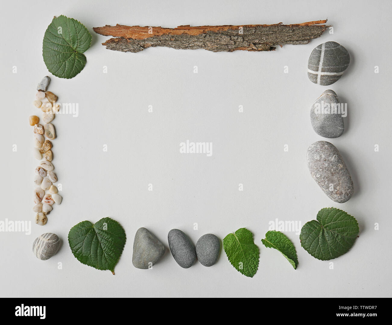 Rectangular frame made of pebbles, leaves and bark isolated on white Stock Photo