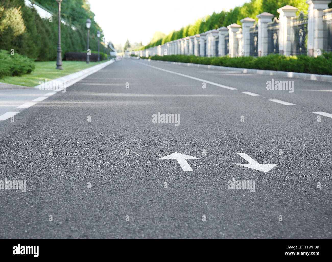 Arrow signs on asphalt road showing direction of movement Stock Photo ...