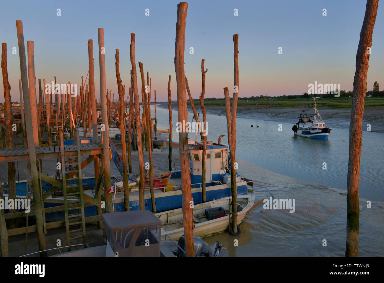 little fishing boats in a fairway at low tide at sunset Stock Photo