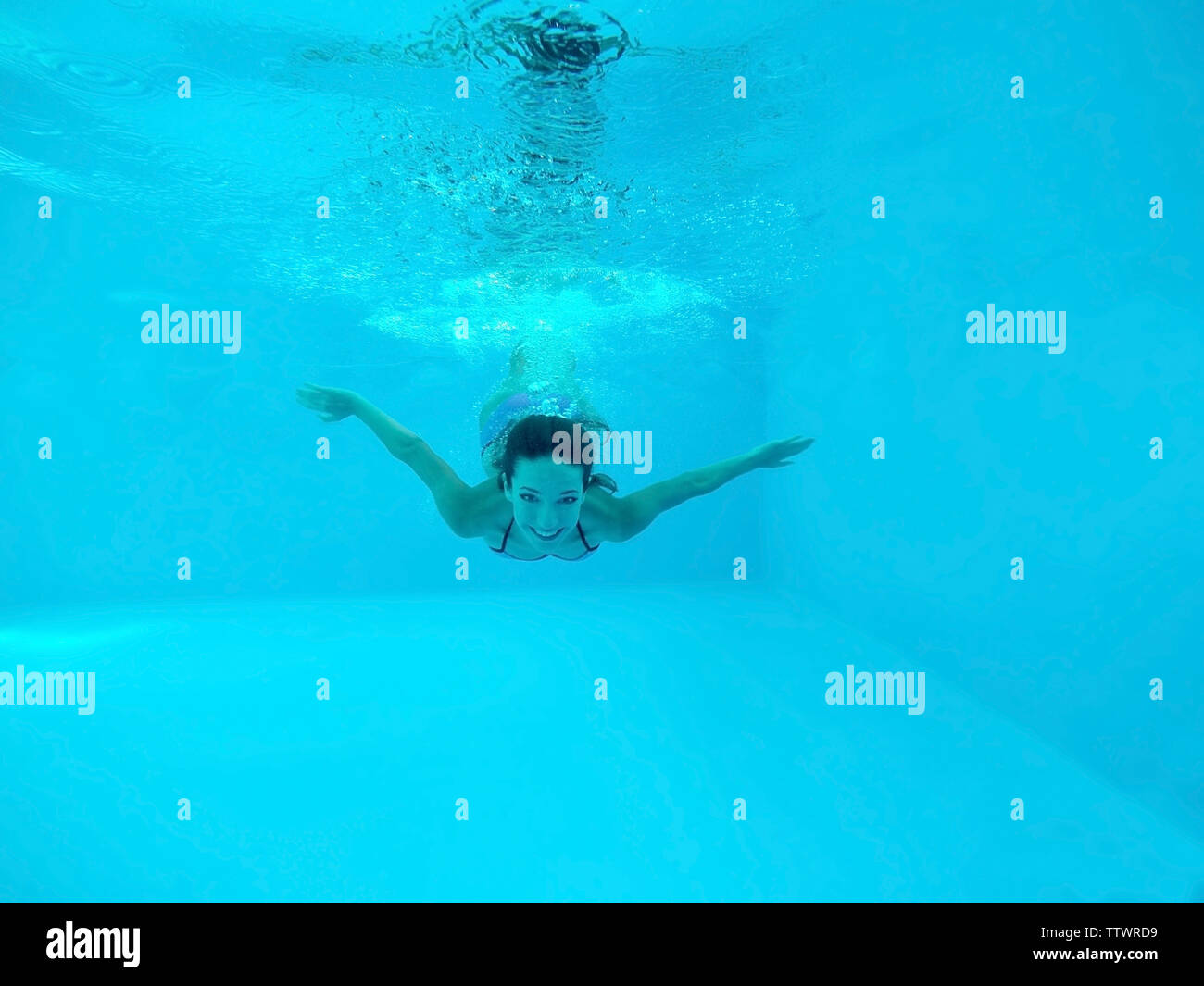 Beautiful young woman swimming under water in pool Stock Photo - Alamy